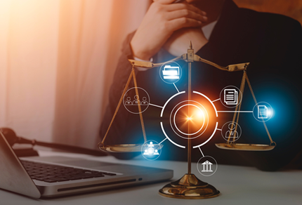 A person sits at a desk with a laptop, behind a brass balance scale and digital legal icons representing law, documents, and communication.