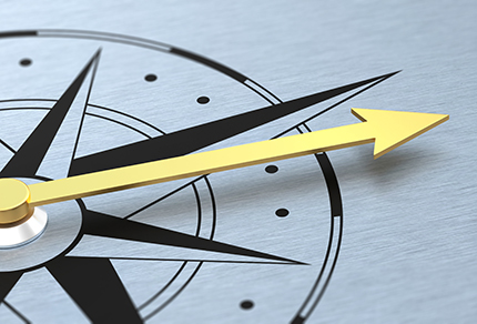 A stylized compass on a metallic background with a prominent yellow arrow pointing to the right, suggesting direction, guidance, or forward movement.